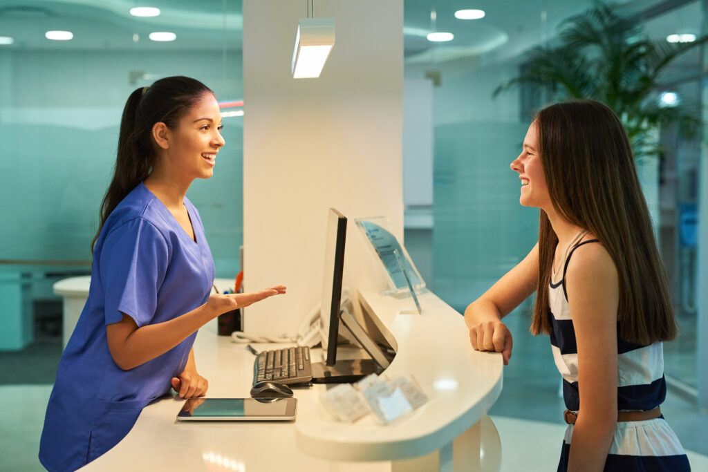What ails you today. Shot of a young nurse assisting a patient at the reception desk